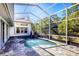 Private screened-in pool featuring a rock waterfall creates a serene outdoor escape in your backyard at 4942 Hidden Oaks Ln, Sarasota, FL 34232