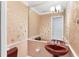 Quaint powder room with pedestal sink, patterned wallpaper, and decorative mirror at 4942 Hidden Oaks Ln, Sarasota, FL 34232