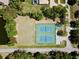 Aerial view of community tennis courts surrounded by mature trees and landscaping near a pond at 4942 Hidden Oaks Ln, Sarasota, FL 34232