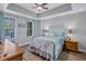Comfortable bedroom with tray ceiling, ceiling fan, and a light blue bed set at 501 Haben Blvd # 202, Palmetto, FL 34221