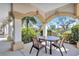 Covered outdoor seating area with table and chairs overlooking lush landscaping and a serene lake at 501 Haben Blvd # 202, Palmetto, FL 34221