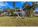 Spacious backyard with a fire pit, palm trees, lush grass, and a two-story home at 504 59Th St, Holmes Beach, FL 34217