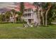 Backyard features a fire pit, Adirondack chairs, tropical foliage, and multi-story deck, ideal for relaxation at 504 59Th St, Holmes Beach, FL 34217