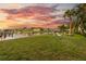 Large backyard with a pristine lawn, waterfront access, boat docks, and sunset views provides a tranquil ambiance at 504 59Th St, Holmes Beach, FL 34217