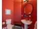 Red powder room with pedestal sink and toilet at 504 59Th St, Holmes Beach, FL 34217
