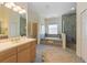 Bathroom featuring a jacuzzi tub, glass enclosed shower, and double sink vanity at 504 59Th St, Holmes Beach, FL 34217