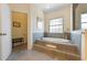Luxurious bathroom features a soaking tub, large window, tiled surround, and neutral color palette at 504 59Th St, Holmes Beach, FL 34217