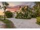 Charming waterfront property featuring lush landscaping, circular driveway, and beautiful sunset views at 504 59Th St, Holmes Beach, FL 34217