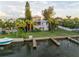 Waterfront home featuring a private dock, lush foliage, and a well maintained lawn at 504 59Th St, Holmes Beach, FL 34217