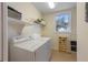 Bright laundry room with front load washer and dryer, storage shelf, and a window at 504 59Th St, Holmes Beach, FL 34217