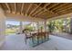 Comfortable covered patio with dining and scenic views of the backyard, canal, and surrounding greenery at 504 59Th St, Holmes Beach, FL 34217