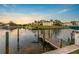Scenic waterfront view featuring a wooden dock, lush foliage, and a glimpse of local residences at 504 59Th St, Holmes Beach, FL 34217