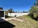 A small stone path in a spacious grassy backyard leads to a white fence at 5104 Silver Bell Dr, Port Charlotte, FL 33948