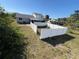 Wide view of a spacious, fenced backyard with a mixture of grass, weeds and bare dirt at 5104 Silver Bell Dr, Port Charlotte, FL 33948