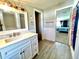 Bright bathroom features a marble vanity top, neutral tiling, and a doorway view to a bedroom at 5104 Silver Bell Dr, Port Charlotte, FL 33948
