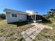 Cozy home featuring a screened porch and a stone tile pathway leading to the entrance at 5104 Silver Bell Dr, Port Charlotte, FL 33948