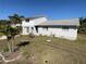 Charming two-story home featuring light gray siding, a well-maintained lawn, and tropical landscaping at 5104 Silver Bell Dr, Port Charlotte, FL 33948