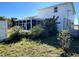 View of the rear house exterior from the yard shows a sunroom addition and side access at 5104 Silver Bell Dr, Port Charlotte, FL 33948