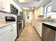 Modern kitchen featuring stainless steel appliances, stylish backsplash, and a view into the laundry room at 5104 Silver Bell Dr, Port Charlotte, FL 33948