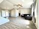 Spacious living room with wood-look flooring, ceiling fan, and sliding glass doors to the outside at 5104 Silver Bell Dr, Port Charlotte, FL 33948