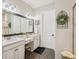 Stylish bathroom with dual sinks, dark wood floors, and a large mirror at 5203 Rushmere Ct, Palmetto, FL 34221