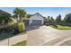 Spacious brick paver driveway leading to a home with a three-car garage, mature landscaping, and a well-kept lawn at 5203 Rushmere Ct, Palmetto, FL 34221