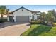 Charming single-story home featuring a brick driveway, mature landscaping, and a spacious three-car garage at 5203 Rushmere Ct, Palmetto, FL 34221