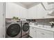 Laundry room with modern washer and dryer, subway tile backsplash, and white cabinets at 5203 Rushmere Ct, Palmetto, FL 34221
