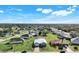 A high-angle view of a neighborhood with houses, trees, and green spaces at 566 Corrientes Cir, Punta Gorda, FL 33983
