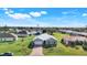 An elevated view of a home featuring a brick driveway, a two-car garage, and well-maintained landscaping at 566 Corrientes Cir, Punta Gorda, FL 33983