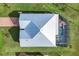 A top-down aerial shot showcases a modern metal roof, a screened-in pool, and meticulous landscaping at 566 Corrientes Cir, Punta Gorda, FL 33983