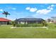 Manicured lawn and landscaping surround the screened-in lanai and backyard of this home at 566 Corrientes Cir, Punta Gorda, FL 33983