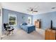 A cozy bedroom features carpeted floors, soft blue walls, and natural light from two windows at 566 Corrientes Cir, Punta Gorda, FL 33983