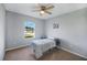 A comfortable bedroom offers a large window for ample natural light and neutral toned walls and carpet at 566 Corrientes Cir, Punta Gorda, FL 33983