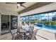 The outdoor lanai features a dining set, grill, and clear view of the beautiful swimming pool at 566 Corrientes Cir, Punta Gorda, FL 33983