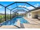 Screened-in pool featuring tiled steps, a sundeck, and a view of the backyard and neighboring homes at 566 Corrientes Cir, Punta Gorda, FL 33983