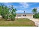 Charming one-story home with a well-maintained lawn, blue sky and lush landscaping at 610 Cumberland Rd, Venice, FL 34293