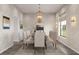 Formal dining room with elegant chandelier, wallpaper, large window, and seating for eight at 6137 Grove Blvd, Punta Gorda, FL 33982
