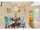 Cozy dining area featuring a glass table, upholstered chairs, and decorative lighting fixture at 6320 Rosefinch Ct # 101, Lakewood Ranch, FL 34202