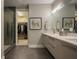 Stylish bathroom with walk-in shower, double vanity, and view into walk-in closet with custom shelving at 635 S Orange Ave # 404, Sarasota, FL 34236
