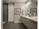 Modern bathroom featuring dual sinks, sleek cabinetry, large mirror, walk-in shower, and elegant fixtures at 635 S Orange Ave # 404, Sarasota, FL 34236
