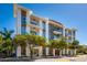 Modern condo building with glass balconies, wood and white accents and lush landscaping at 635 S Orange Ave # 404, Sarasota, FL 34236