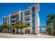 Modern building featuring a textured facade, glass balconies, and mature trees along the street at 635 S Orange Ave # 404, Sarasota, FL 34236