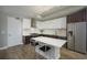 Sleek, modern kitchen boasts stainless steel appliances, an island with seating, and two-tone cabinetry at 635 S Orange Ave # 404, Sarasota, FL 34236