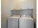 Laundry area with a side-by-side washer and dryer, and upper cabinets for storage at 635 S Orange Ave # 404, Sarasota, FL 34236