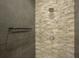 Detailed view of a stone-tiled walk-in shower with modern fixtures and a built-in shelf at 635 S Orange Ave # 404, Sarasota, FL 34236