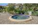Community hot tub with tile accents, surrounded by lush landscaping and lounge chairs at 6450 Wild Oak Bay Blvd # 240, Bradenton, FL 34210