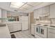 Bright kitchen features white appliances, cabinets, countertops, and a window into the adjacent living room at 6450 Wild Oak Bay Blvd # 240, Bradenton, FL 34210