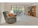 Bright living room with neutral carpet, slider to porch and a comfortable recliner chair at 6450 Wild Oak Bay Blvd # 240, Bradenton, FL 34210