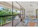 Enclosed outdoor patio with a ceiling fan, table, seating and views of a pond and trees at 6450 Wild Oak Bay Blvd # 240, Bradenton, FL 34210